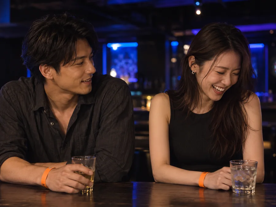 声を上げて笑う男性と、口を手で覆って驚く女性。ふたりともオレンジのリストバンドを付けている